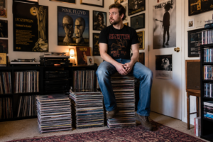 A man sitting on a stack of records